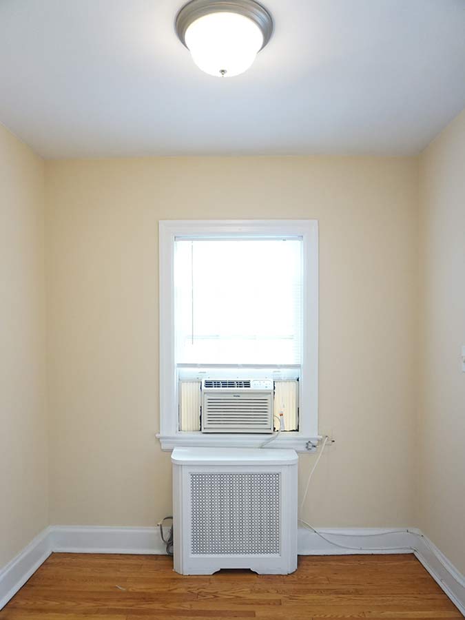 Bedroom with a window AC unit in an apartment at Edgehill Court in Bala Cynwyd, PA.