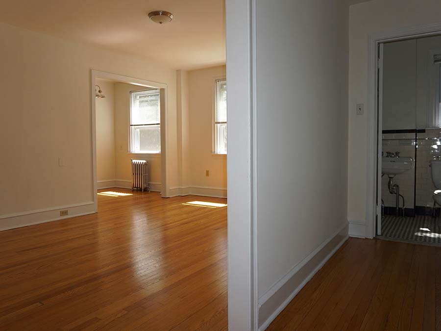 Spacious living room space and hallway to bathroom in an apartment at Hazel Apartments in Upper Darby, PA.