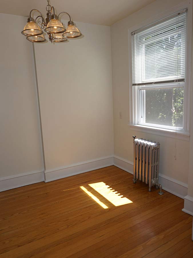 Corner of a bedroom with hanging lights and window in an apartment at Hazel Apartments in Upper Darby, PA.