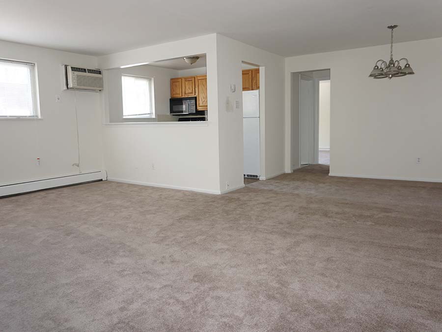 Carpeted living room connected to the kitchen at Landon Court apartments in Lansdowne, PA.