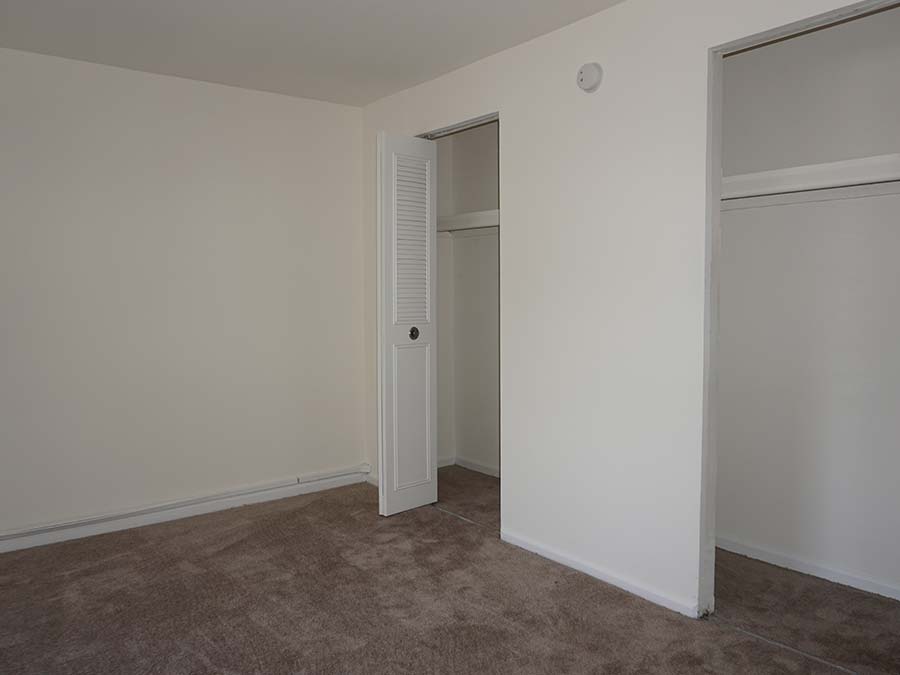 Carpeted bedroom with closet space in an apartment at Landon Court in Lansdowne, PA.