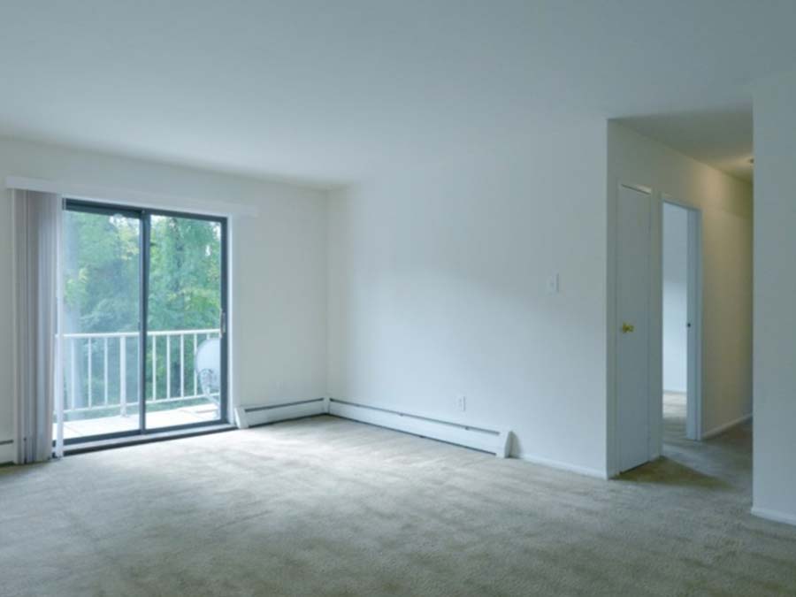 Carpeted living room leading to a balcony at Ridgeway Court in Lansdowne, PA.