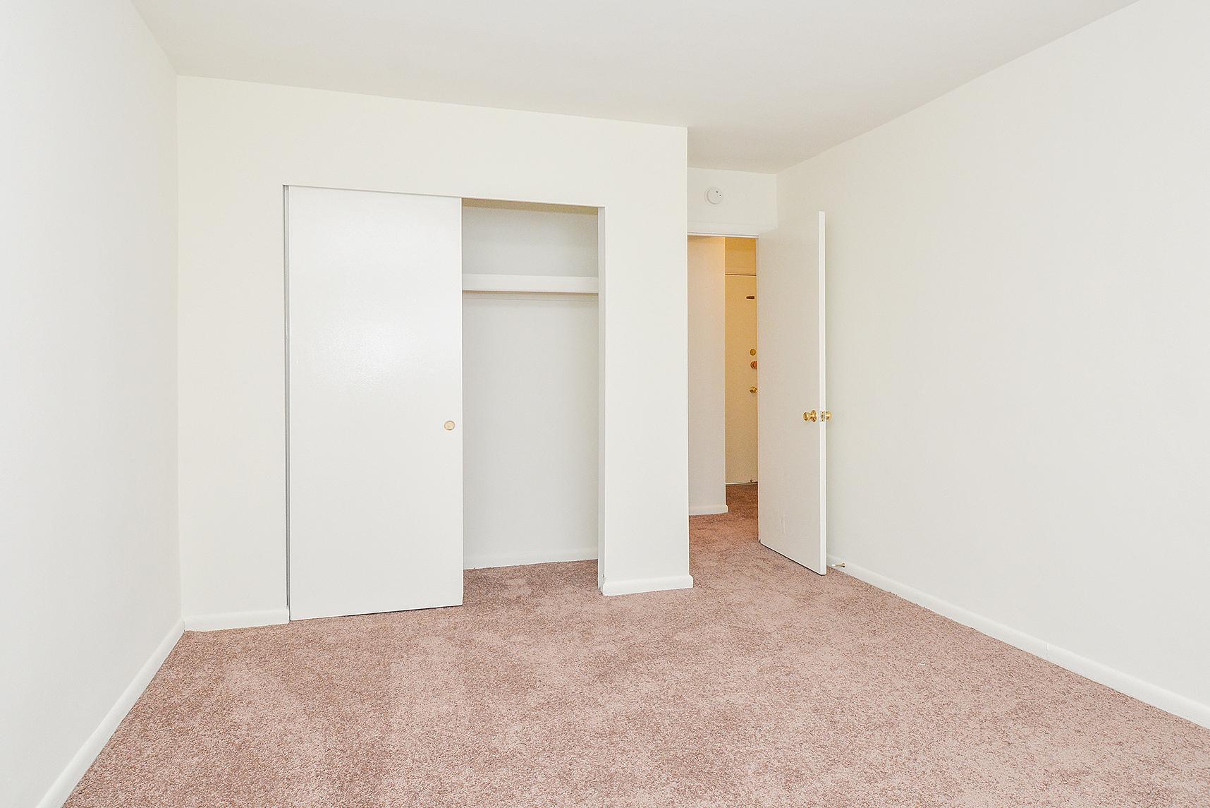 Carpeted bedroom with a spacious closet in an apartment at Hazel Apartments in Clifton Heights, PA.