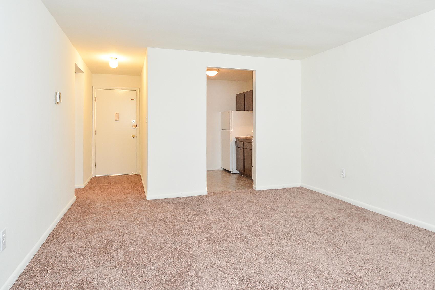 Carpeted living room area in an apartment at Hazel Apartments in Clifton Heights, PA.
