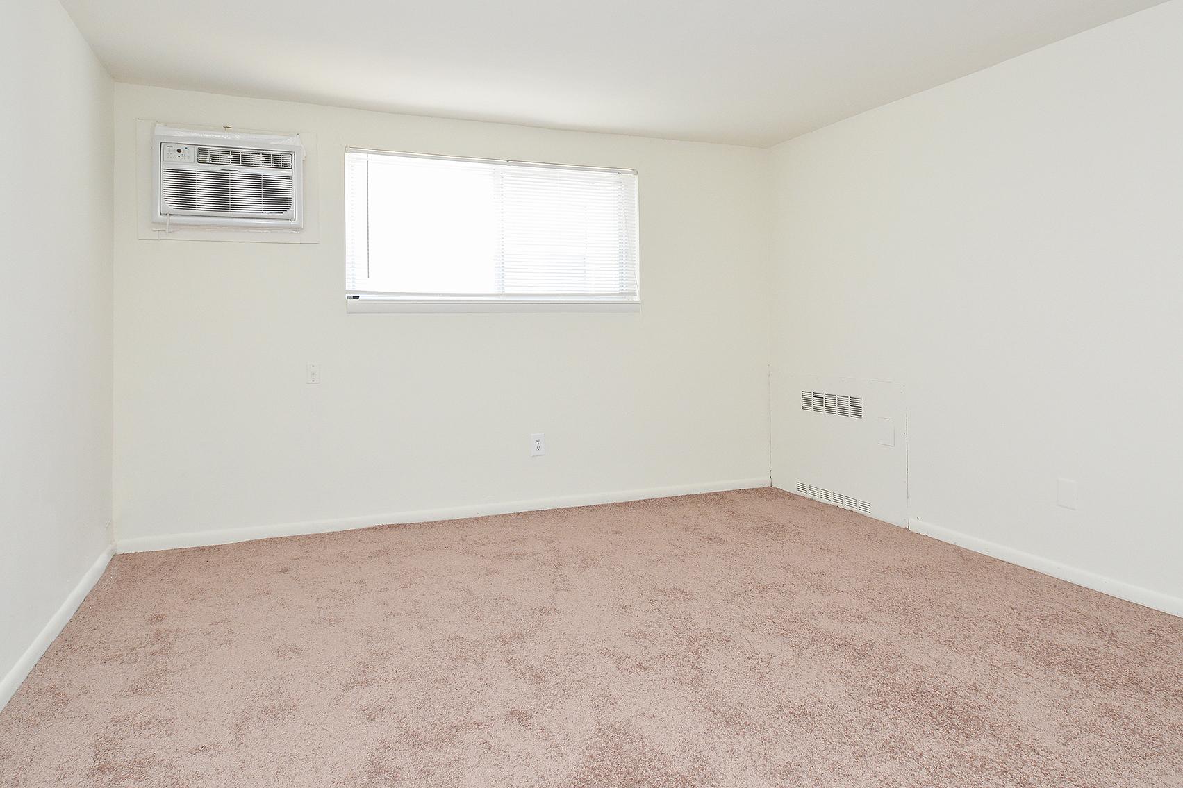 Carpeted bedroom space in an apartment at Hazel Apartments in Clifton Heights, PA.