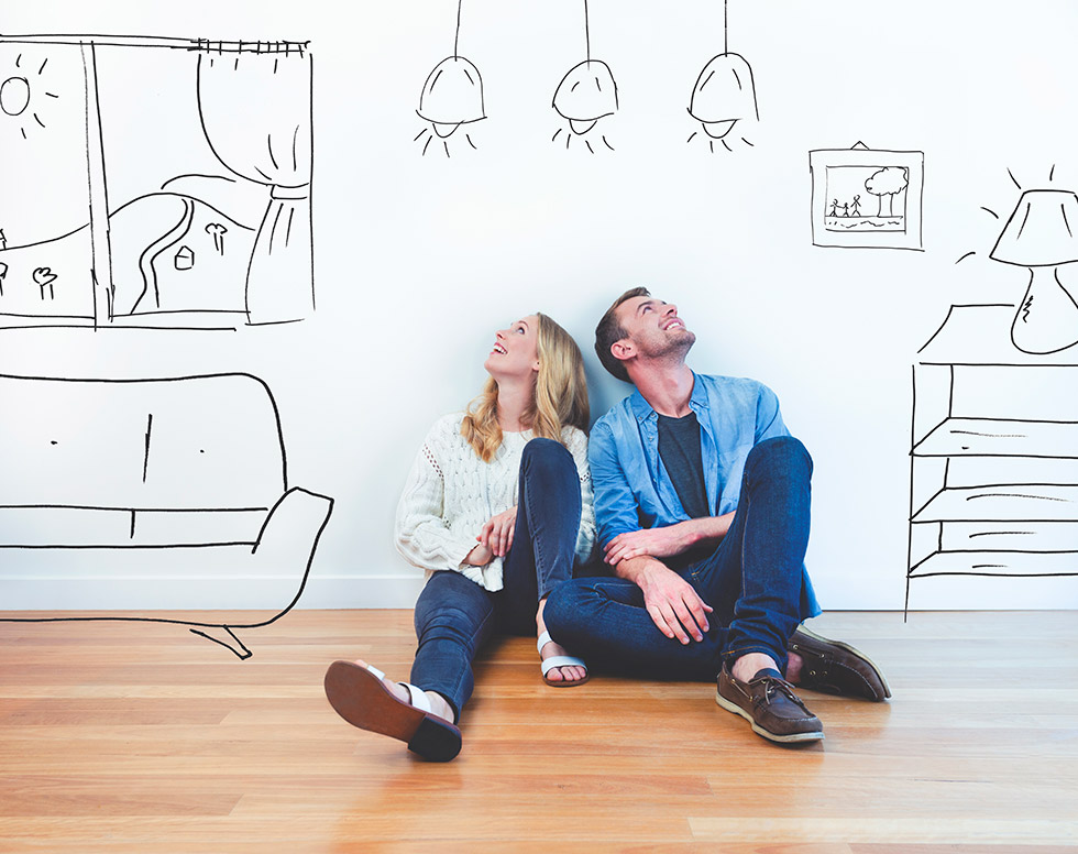 Two people looking up at a white wall with home decor drawings on it