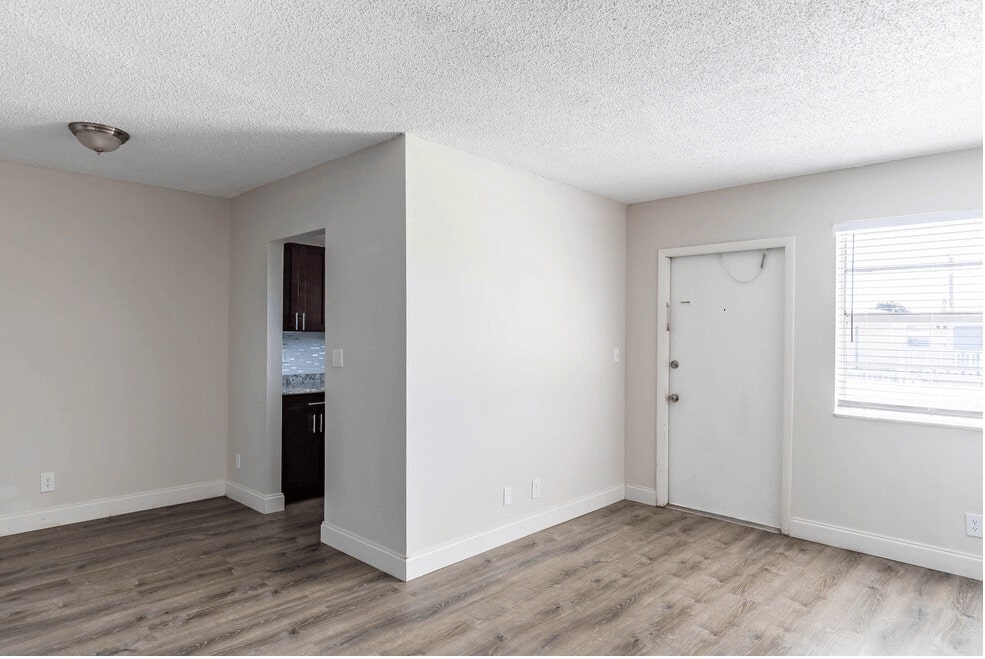 Front door leading to the living area with grey wood-like flooring at The Villas apartments in Boynton Beach, FL.